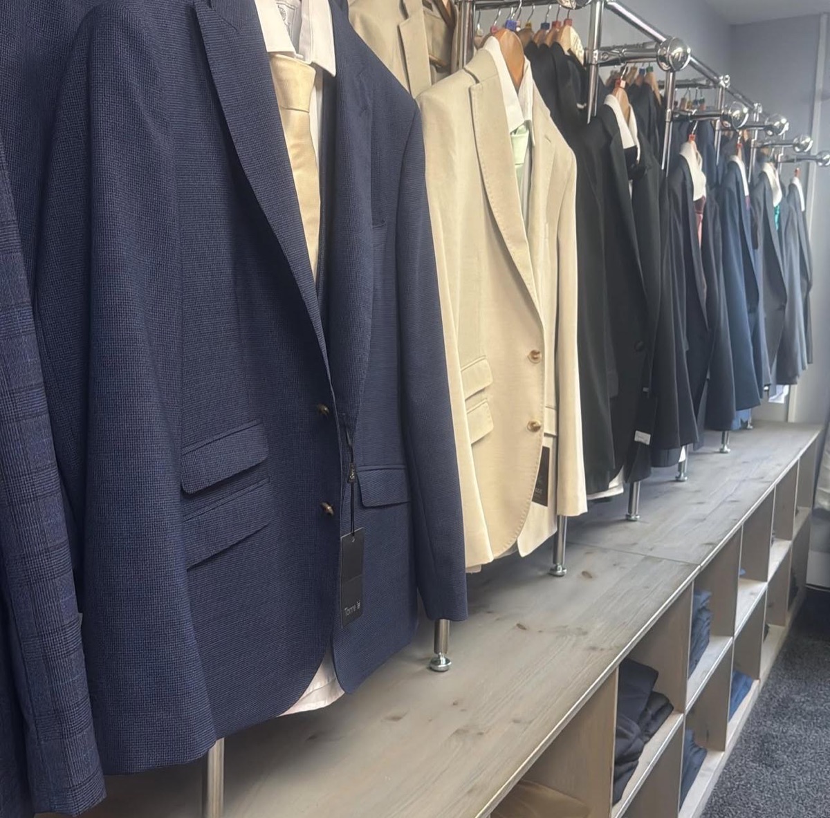 A rail of Marc Darcy wedding suits in the menswear department